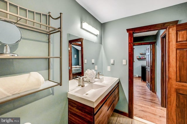 bathroom featuring vanity, a baseboard heating unit, and hardwood / wood-style flooring