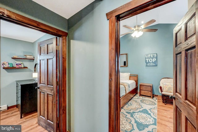 hall featuring lofted ceiling and light hardwood / wood-style flooring