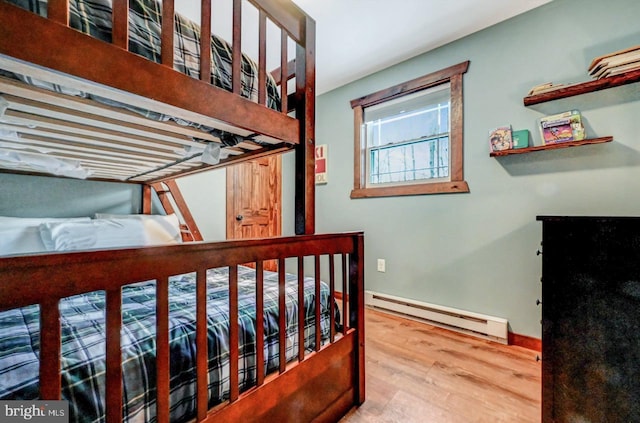 bedroom with a baseboard radiator and hardwood / wood-style floors