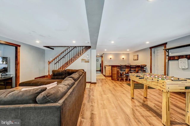 living room with light hardwood / wood-style floors and bar