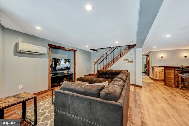 living room featuring light hardwood / wood-style flooring and a wall unit AC