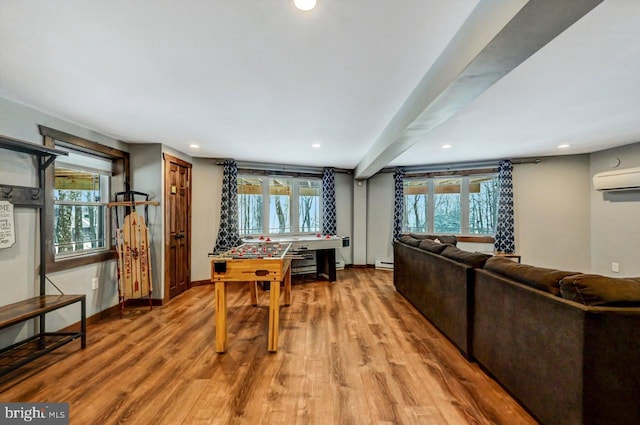 interior space with hardwood / wood-style flooring, an AC wall unit, and a healthy amount of sunlight