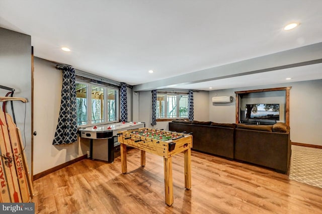 game room featuring light hardwood / wood-style flooring and a wall mounted air conditioner