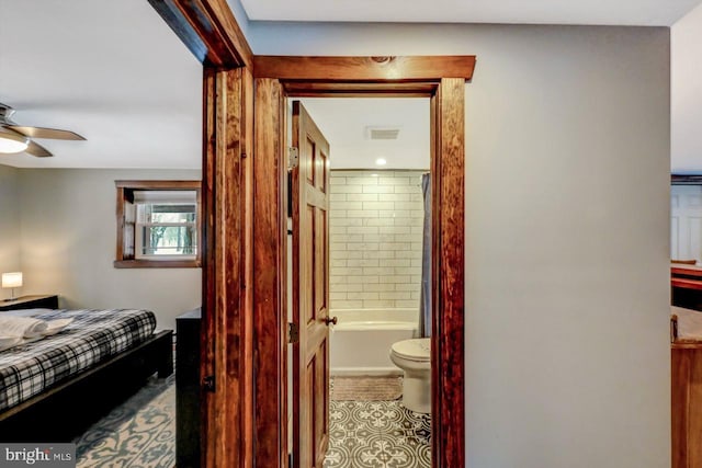 interior space featuring ceiling fan, ensuite bath, and tile patterned flooring