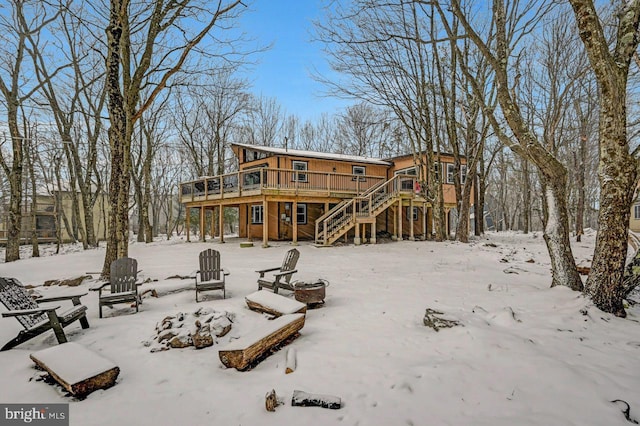 snow covered property with a deck and a fire pit