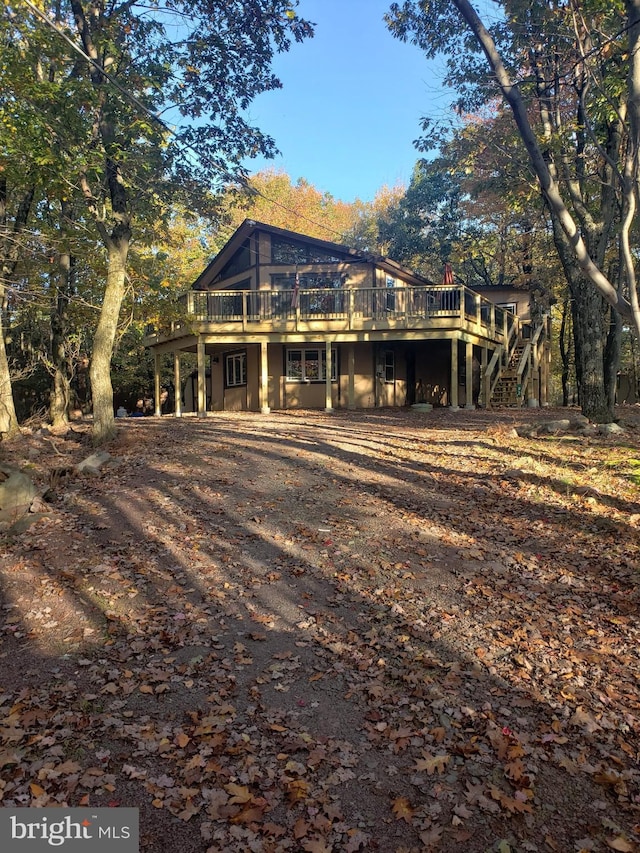 rear view of house featuring a wooden deck