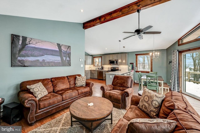 living room with vaulted ceiling with beams, light wood-type flooring, and ceiling fan with notable chandelier