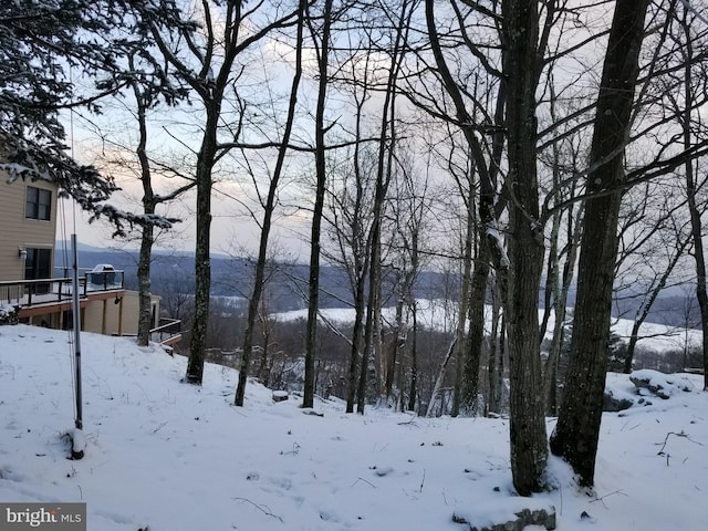 yard covered in snow featuring a mountain view