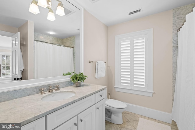 bathroom with toilet, vanity, and tile patterned floors