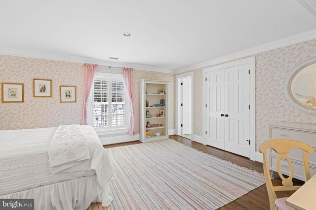 bedroom with ornamental molding, a closet, and dark hardwood / wood-style floors