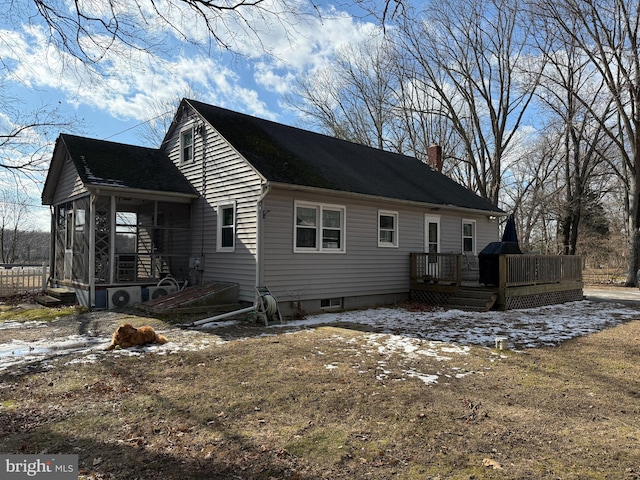 view of side of property with a wooden deck and a sunroom