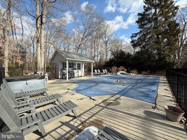 view of pool featuring an outbuilding, a patio area, and a jacuzzi