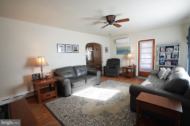 living room with ceiling fan, a baseboard heating unit, hardwood / wood-style floors, and an AC wall unit