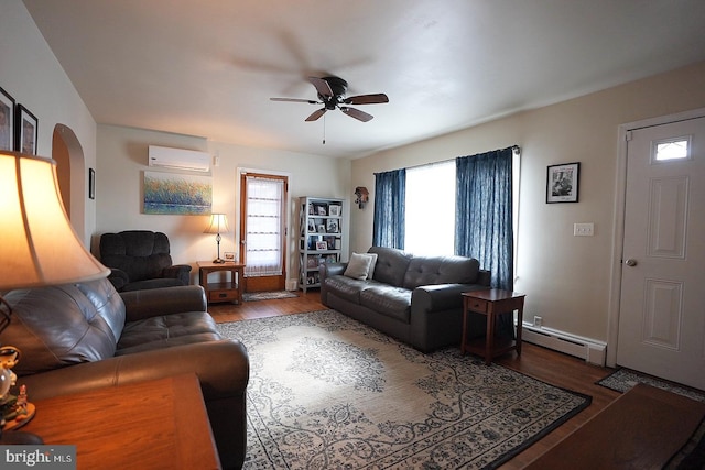 living room with hardwood / wood-style flooring, a baseboard radiator, an AC wall unit, and ceiling fan