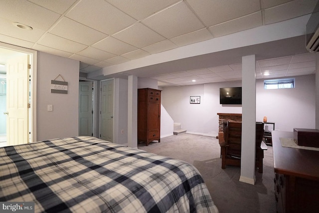 bedroom featuring carpet, a wall mounted AC, and a drop ceiling