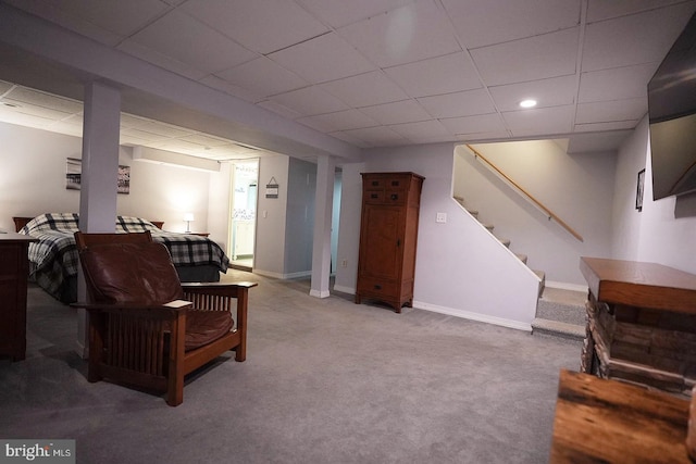 living room with a paneled ceiling and carpet flooring