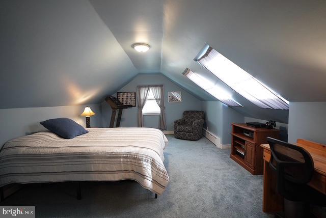 bedroom featuring a baseboard radiator, light colored carpet, and vaulted ceiling