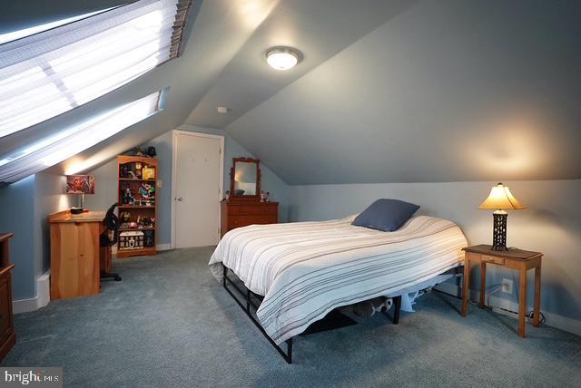 carpeted bedroom featuring vaulted ceiling