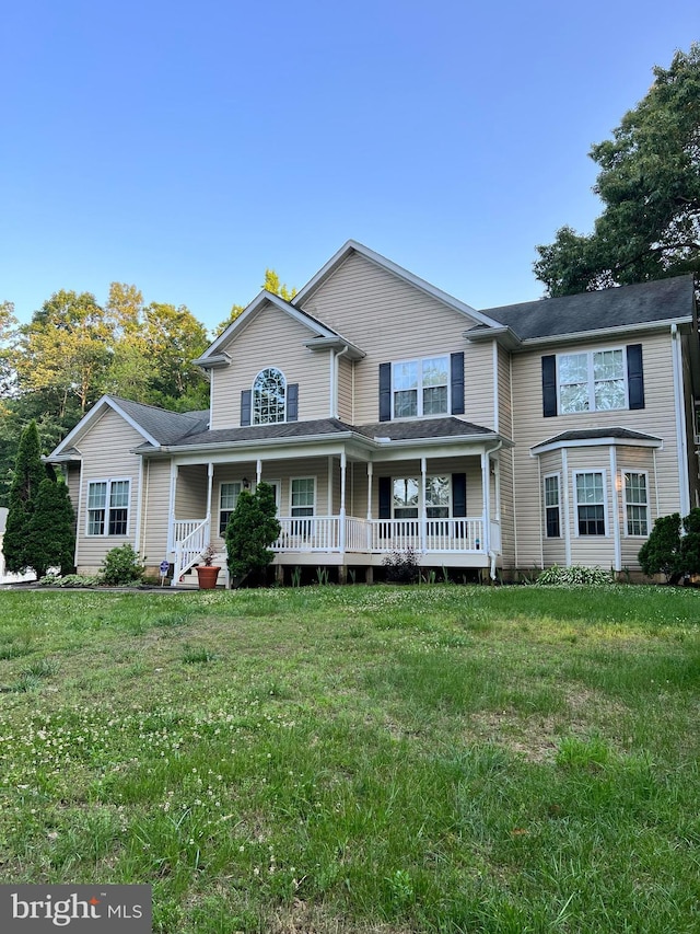 view of front of house with covered porch and a front lawn