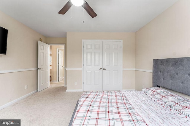 unfurnished bedroom featuring ceiling fan, a closet, and light carpet