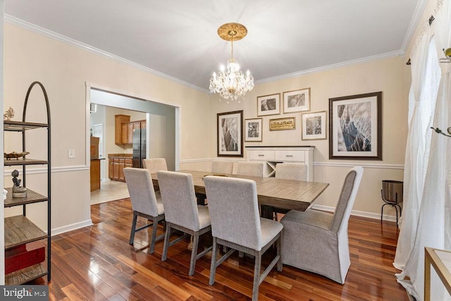 dining space with dark hardwood / wood-style flooring, crown molding, and a chandelier