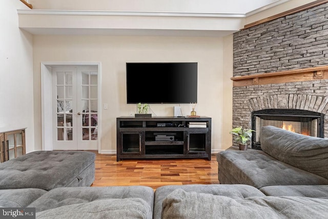 living room featuring wood-type flooring, french doors, and a fireplace