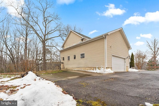 snow covered property with a garage