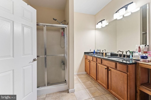 bathroom with tile patterned floors, a shower with door, and vanity