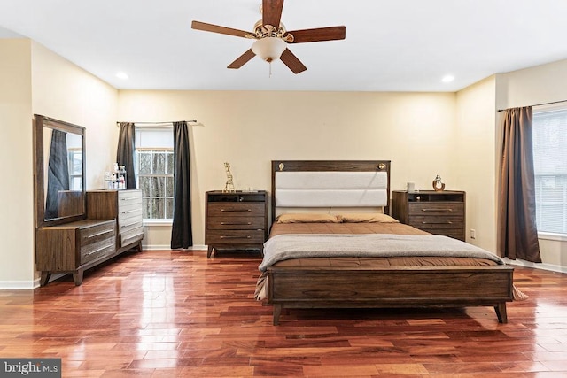 bedroom featuring ceiling fan, multiple windows, and hardwood / wood-style flooring