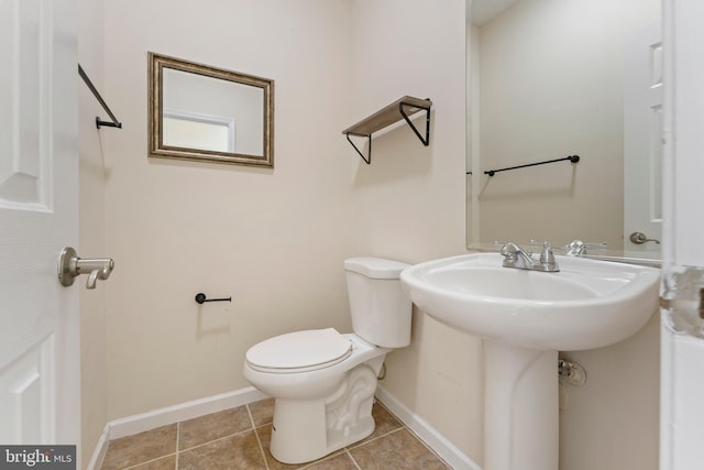 bathroom with tile patterned floors, baseboards, and toilet
