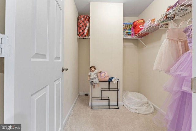 spacious closet featuring light colored carpet