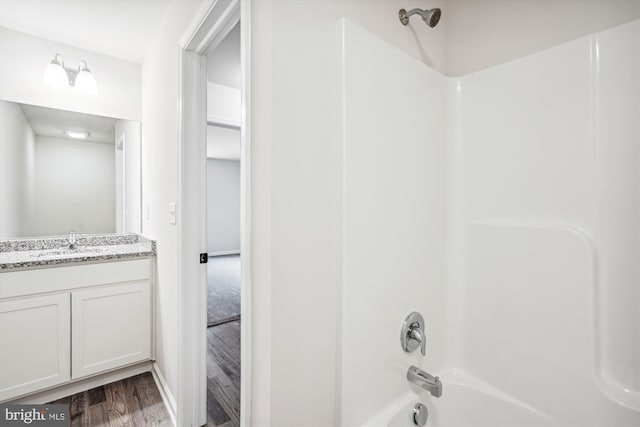 bathroom featuring vanity, hardwood / wood-style floors, and bathing tub / shower combination