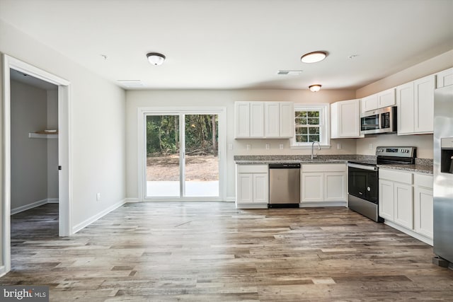 kitchen featuring white cabinets, light hardwood / wood-style floors, and appliances with stainless steel finishes