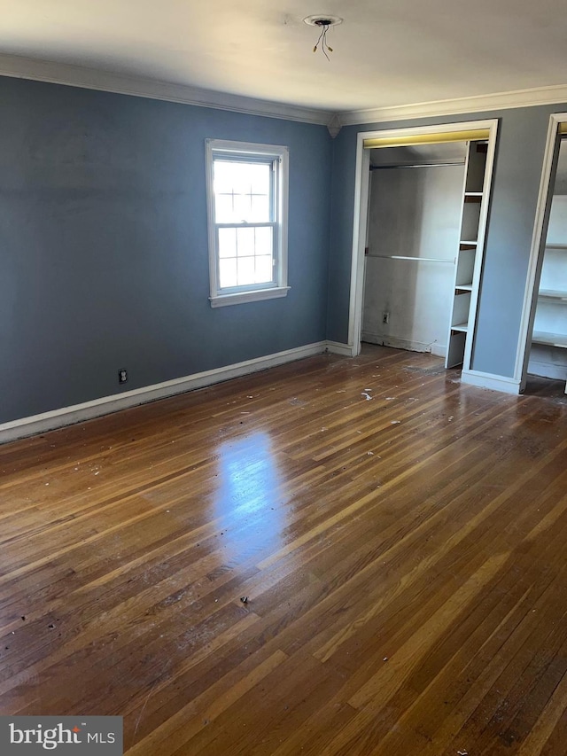 unfurnished bedroom with dark hardwood / wood-style flooring, a closet, and ornamental molding