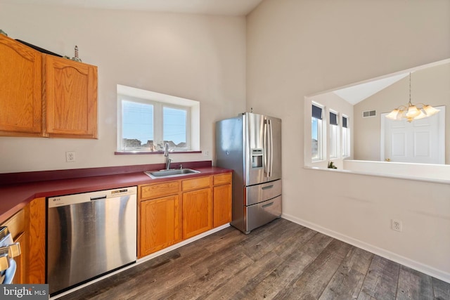 kitchen featuring stainless steel appliances, sink, lofted ceiling, a chandelier, and plenty of natural light