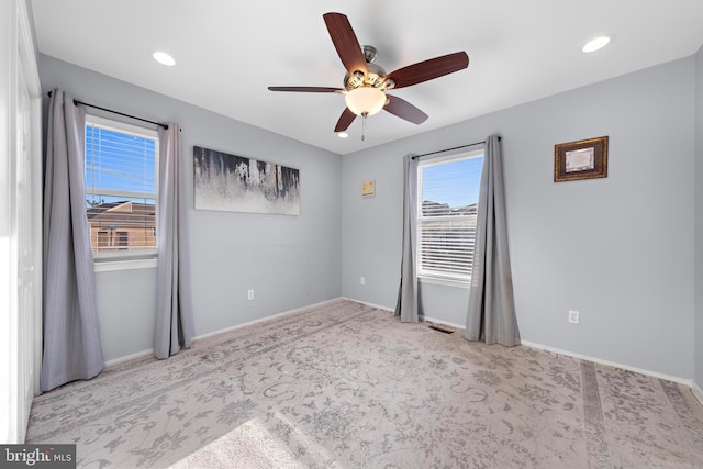 carpeted spare room with ceiling fan