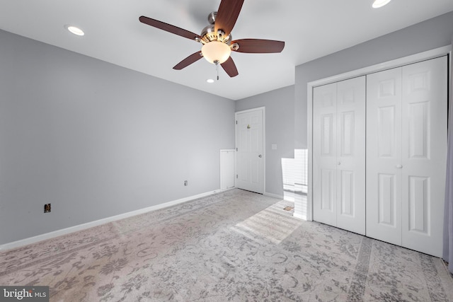 unfurnished bedroom with light carpet, a closet, and ceiling fan