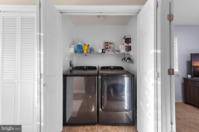 clothes washing area with light colored carpet and washing machine and dryer