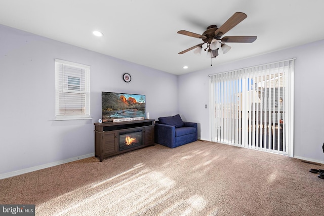 living area featuring carpet floors and ceiling fan