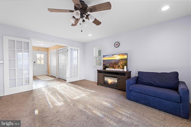 carpeted living room with french doors and ceiling fan