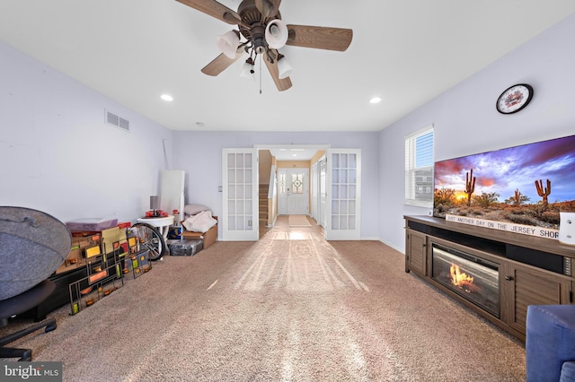 recreation room with light colored carpet, ceiling fan, and french doors