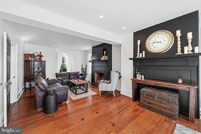 living room featuring hardwood / wood-style floors and a large fireplace