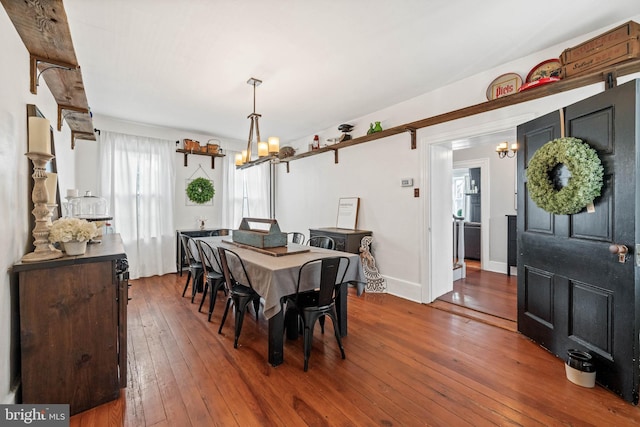 dining area featuring dark hardwood / wood-style flooring and a chandelier