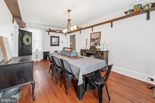 dining area featuring dark hardwood / wood-style flooring and a chandelier