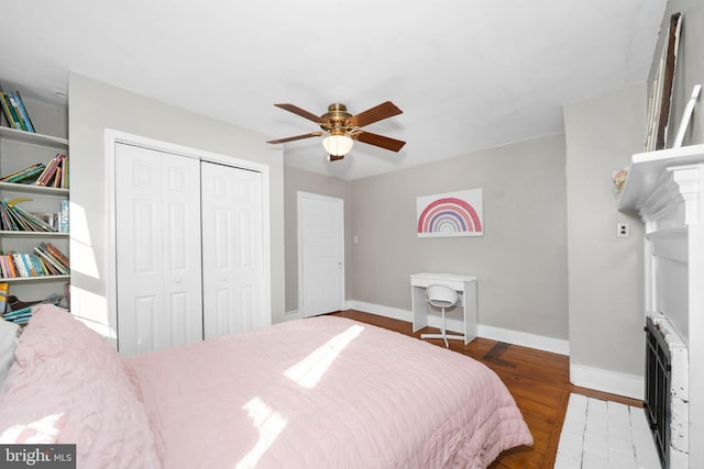 bedroom with heating unit, ceiling fan, a closet, and hardwood / wood-style floors