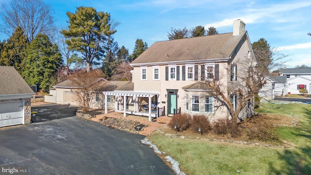 view of front facade with a front lawn, a garage, and an outdoor structure