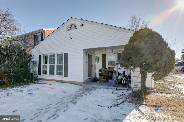 snow covered house featuring a porch