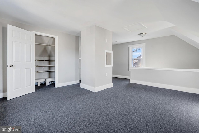 interior space featuring vaulted ceiling and dark colored carpet