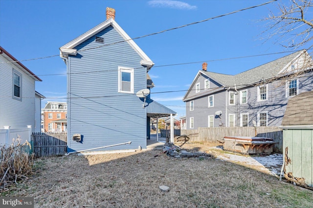 rear view of property featuring a hot tub