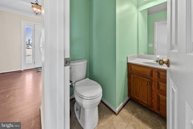 bathroom with vanity, ornamental molding, and toilet